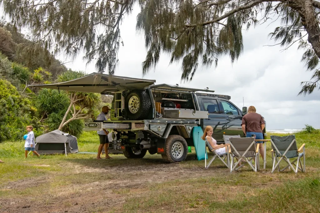 Chevrolet Silverado 2500 with Norweld Compact Deluxe Canopy set up at a coastal family campsite