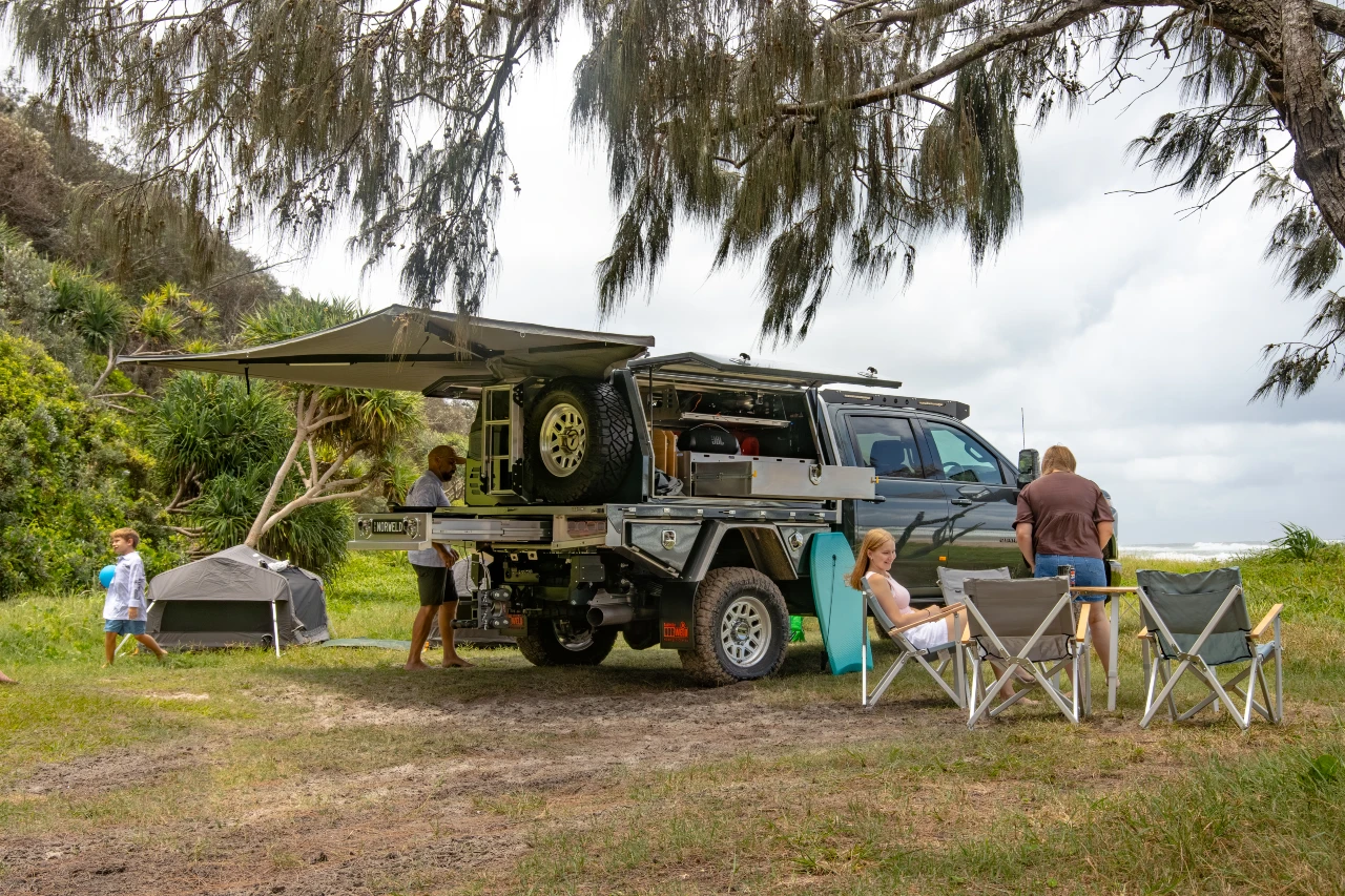 Chevrolet Silverado 2500 with Norweld Compact Deluxe Canopy set up at a coastal family campsite