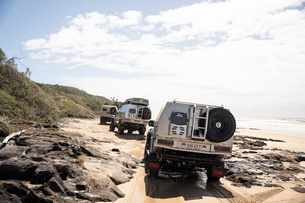 Toyota LandCruiser 79 Series vehicles with Norweld canopies travelling along a rocky beach track