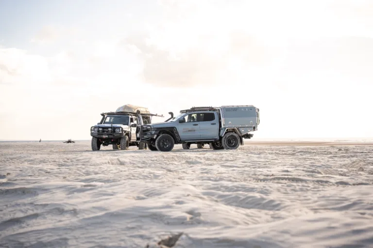 Toyota LandCruiser 79 Series with Norweld canopy alongside another touring 4WD on the beach
