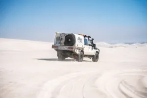 Toyota LandCruiser 79 Series with Norweld canopy driving through coastal sand dunes